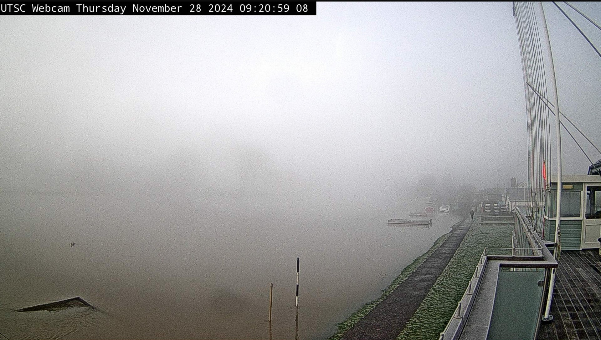 The fog moves in over a frosted path The river is rising approaching the path