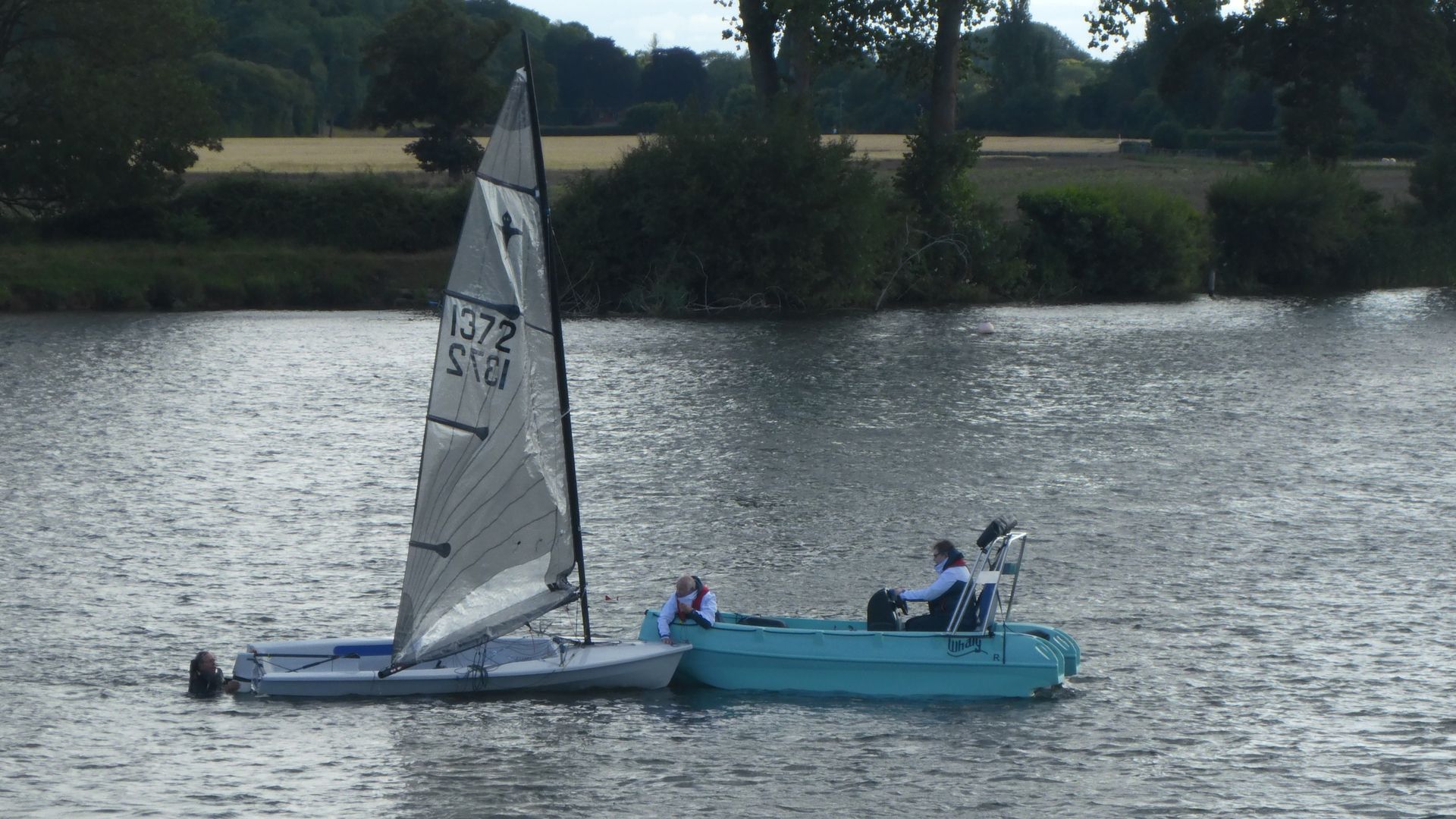 sailing boat rescue, the dinghy had capsized. I am holding onto the boat whilst the helm in the whaly tows the boat and the sailor in the water back to the bank