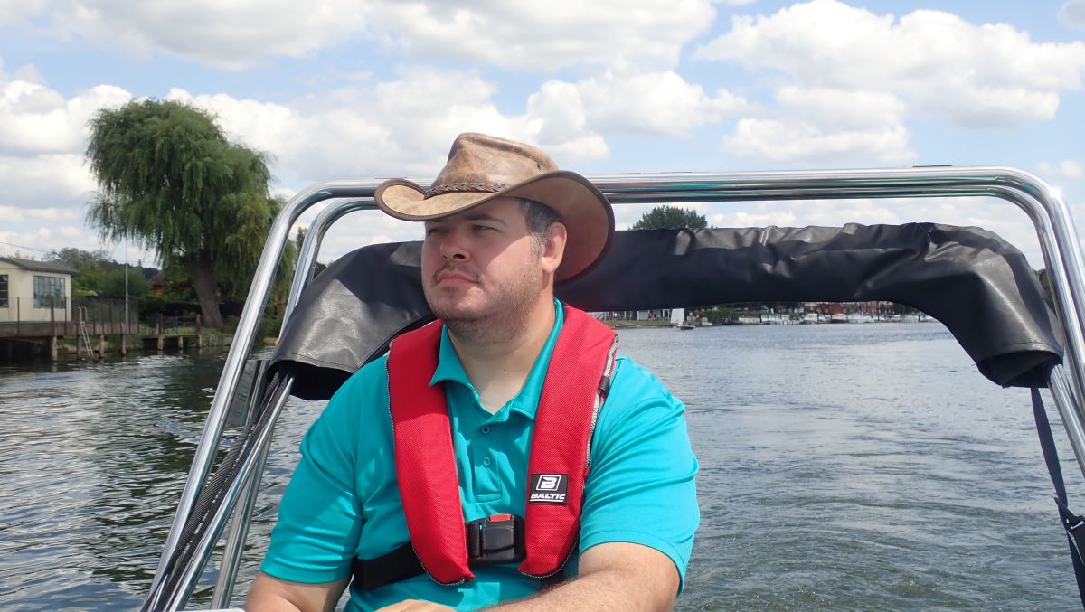 Paul cruising in the Whakly on the River Thames, wearing a red life jacket